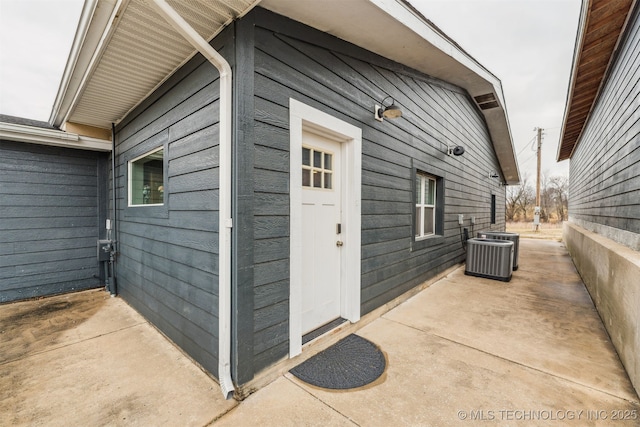 doorway to property featuring central AC unit and a patio area