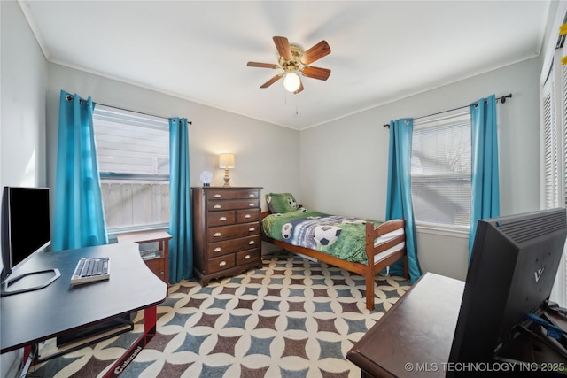 carpeted bedroom with ceiling fan, ornamental molding, and multiple windows