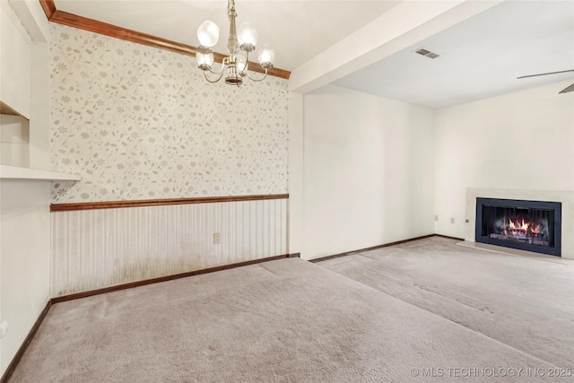 unfurnished living room featuring ceiling fan with notable chandelier and light colored carpet