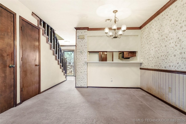 carpeted spare room with crown molding and an inviting chandelier