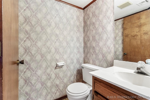 bathroom featuring vanity, crown molding, and toilet