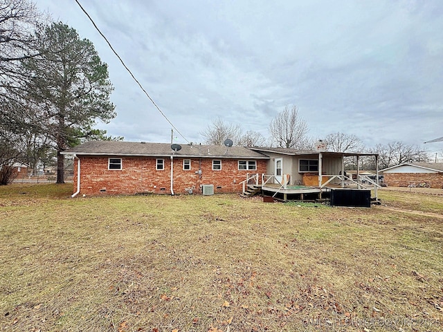 back of property featuring central AC, a deck, and a lawn