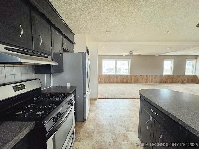 kitchen with ceiling fan, stainless steel range with gas cooktop, a textured ceiling, and backsplash