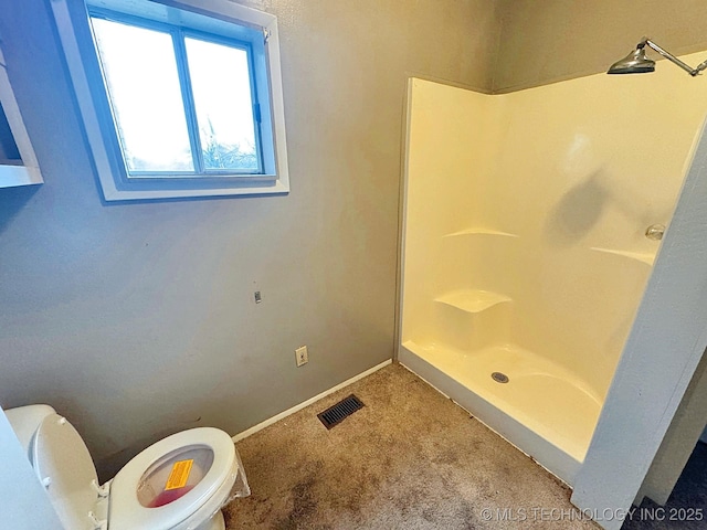 bathroom with toilet and a shower