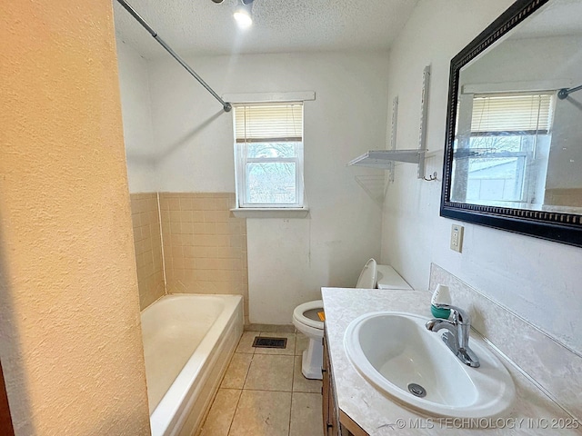 bathroom featuring vanity, tile patterned floors, toilet, and a textured ceiling