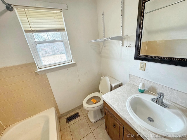 bathroom with vanity, toilet, tile patterned flooring, and a tub