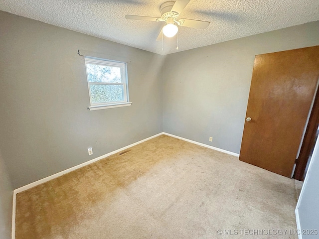 carpeted empty room featuring ceiling fan and a textured ceiling