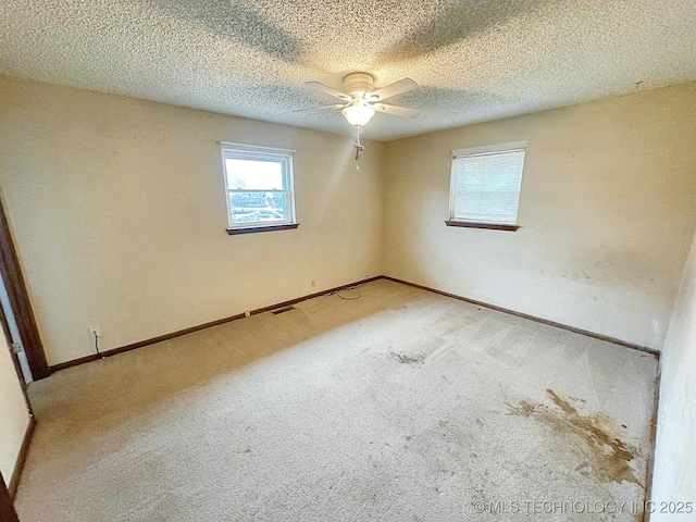 carpeted empty room with a textured ceiling and ceiling fan