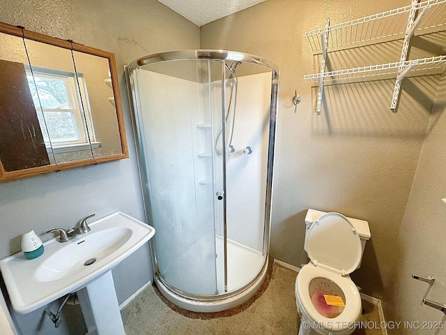 bathroom with toilet, sink, a textured ceiling, and walk in shower