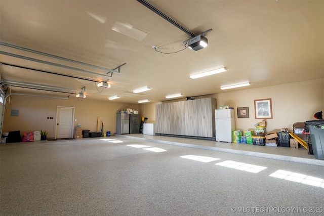 garage featuring a garage door opener, stainless steel fridge, and white refrigerator