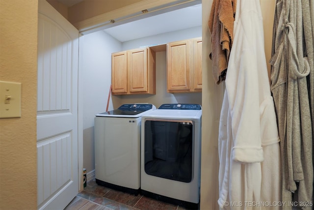 laundry area with washing machine and clothes dryer and cabinets