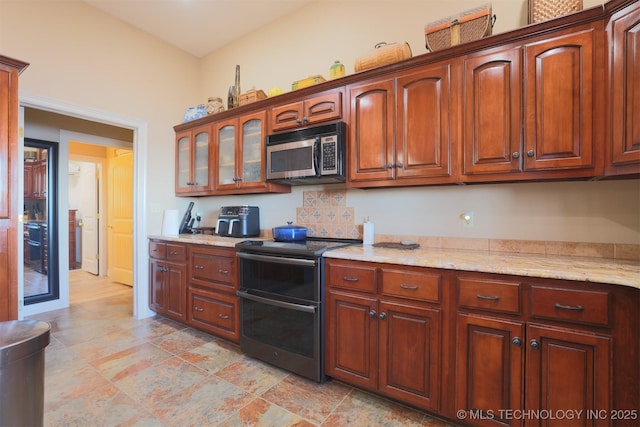 kitchen with appliances with stainless steel finishes and light stone counters