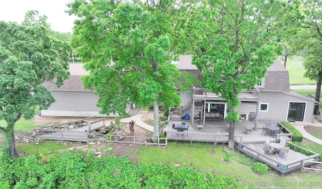 rear view of house featuring a shingled roof, stairway, fence, and a wooden deck