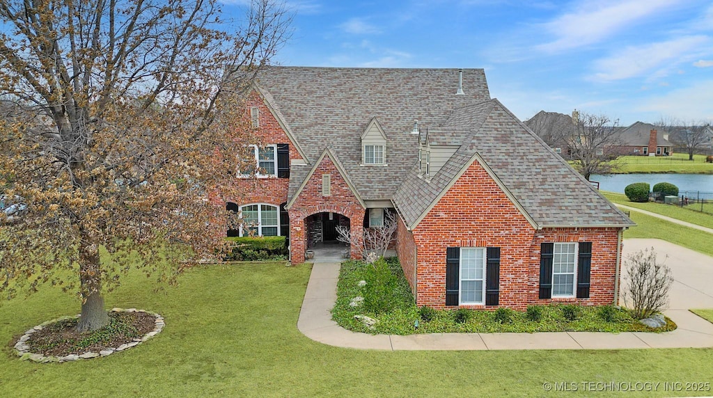 tudor home featuring a front lawn