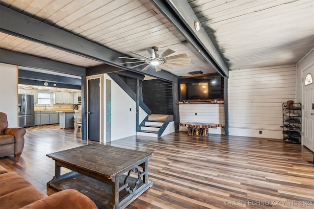 living room with sink, hardwood / wood-style flooring, beamed ceiling, and ceiling fan