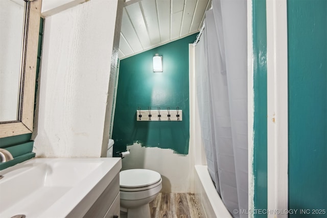 full bathroom featuring sink, hardwood / wood-style floors, shower / tub combo with curtain, and toilet