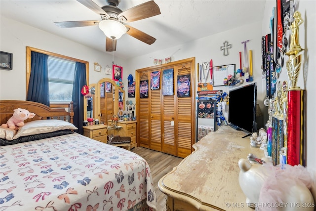 bedroom featuring ceiling fan, light wood-type flooring, and a closet