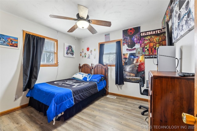 bedroom featuring multiple windows, ceiling fan, and light wood-type flooring