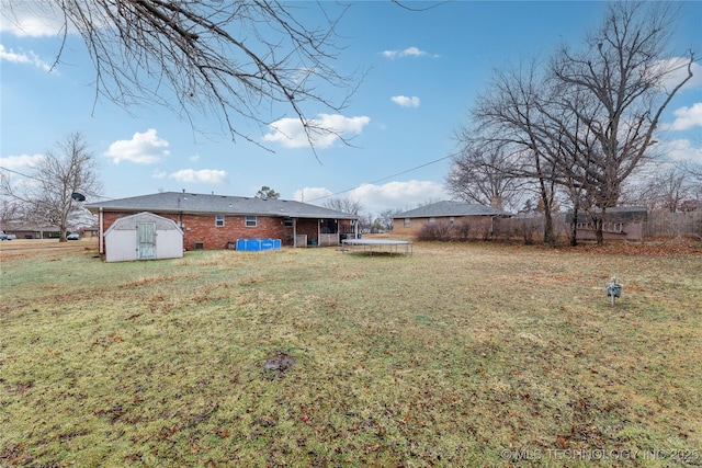 view of yard featuring a trampoline and a shed