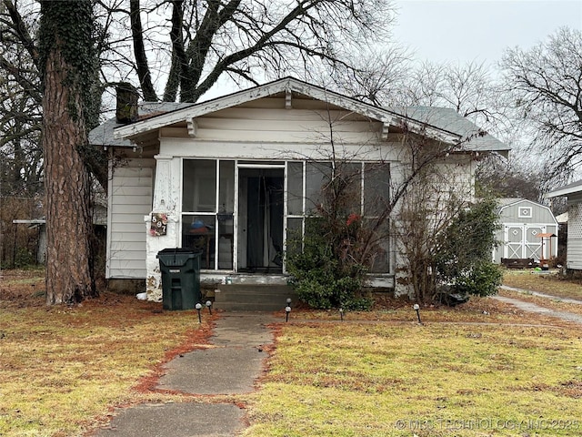 bungalow-style home featuring a front lawn