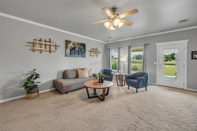 carpeted living room featuring crown molding and ceiling fan