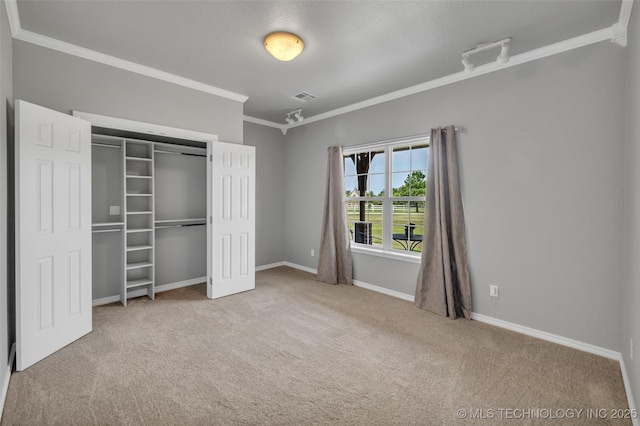 unfurnished bedroom with crown molding, carpet flooring, and a closet