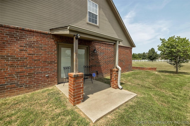 property entrance featuring a yard and a patio