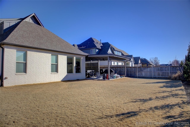 back of property with a yard and a patio area