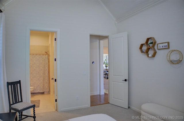 bedroom with crown molding, light colored carpet, connected bathroom, and vaulted ceiling