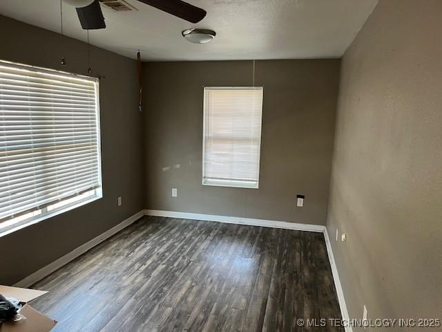 empty room with dark hardwood / wood-style floors and ceiling fan