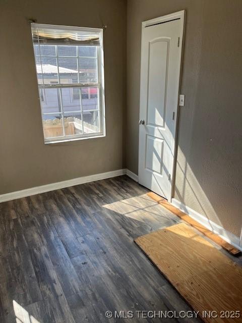 unfurnished room with dark hardwood / wood-style flooring