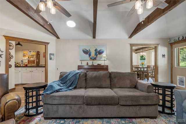 living room featuring lofted ceiling with beams, ceiling fan, and light wood-type flooring