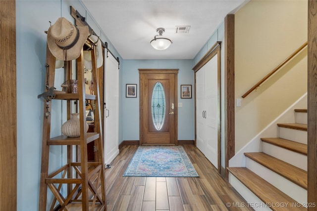 foyer with hardwood / wood-style flooring and a barn door