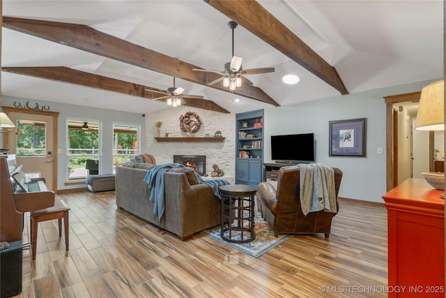 living room with ceiling fan, a fireplace, light wood-type flooring, and vaulted ceiling with beams