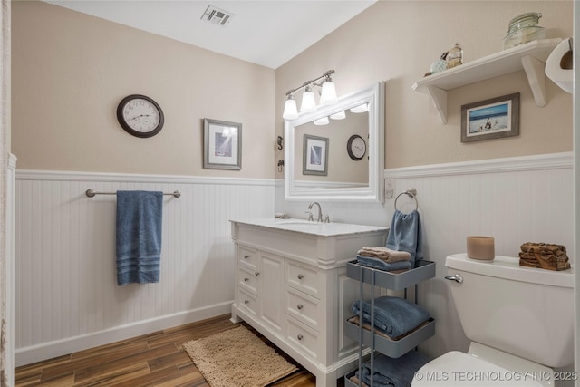 bathroom with wood-type flooring, vanity, and toilet