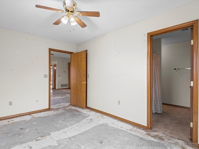 empty room with a textured ceiling and ceiling fan