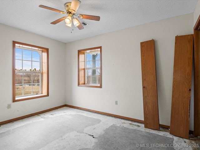 unfurnished room with ceiling fan and a textured ceiling