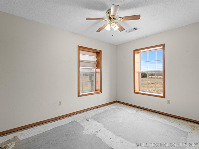 unfurnished room with ceiling fan, concrete flooring, and a textured ceiling