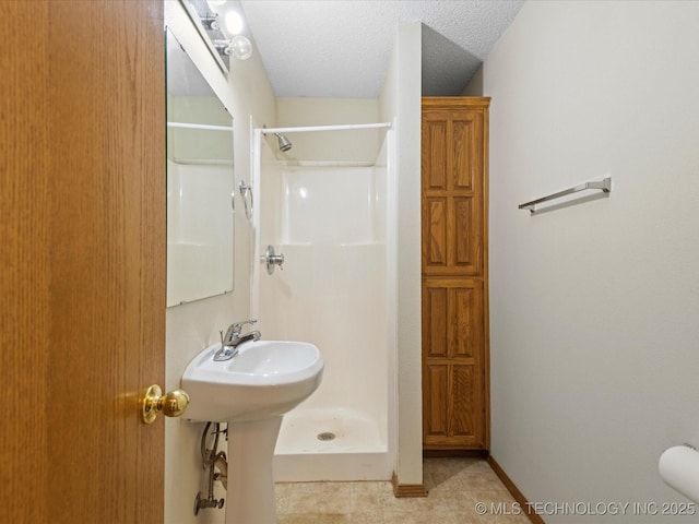 bathroom featuring sink, a textured ceiling, and walk in shower