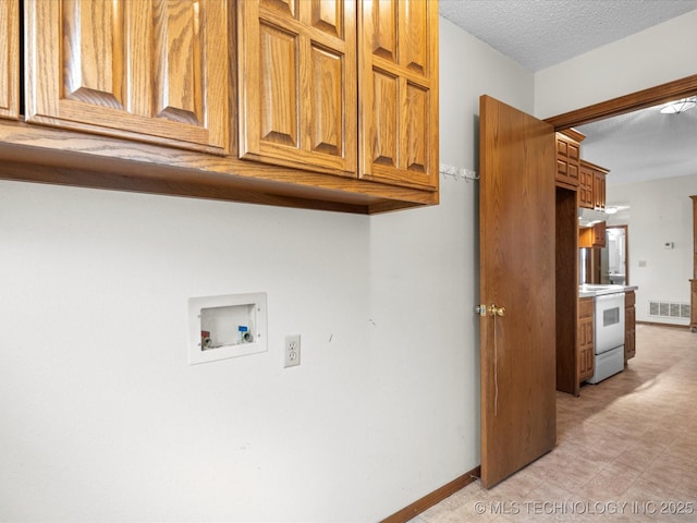 laundry room with cabinets, hookup for a washing machine, and a textured ceiling