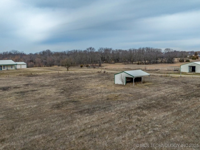 view of yard featuring an outdoor structure and a rural view