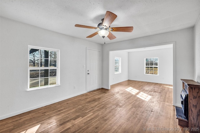 unfurnished living room featuring hardwood / wood-style flooring, a textured ceiling, and ceiling fan