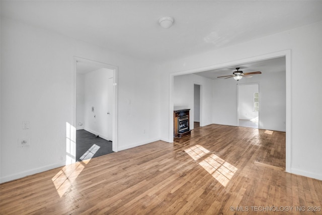 unfurnished living room featuring hardwood / wood-style flooring and ceiling fan