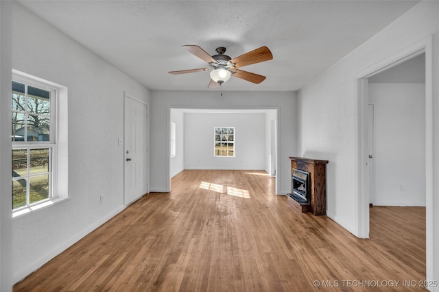 unfurnished living room with a fireplace, plenty of natural light, and light hardwood / wood-style floors