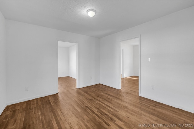 spare room featuring hardwood / wood-style floors and a textured ceiling