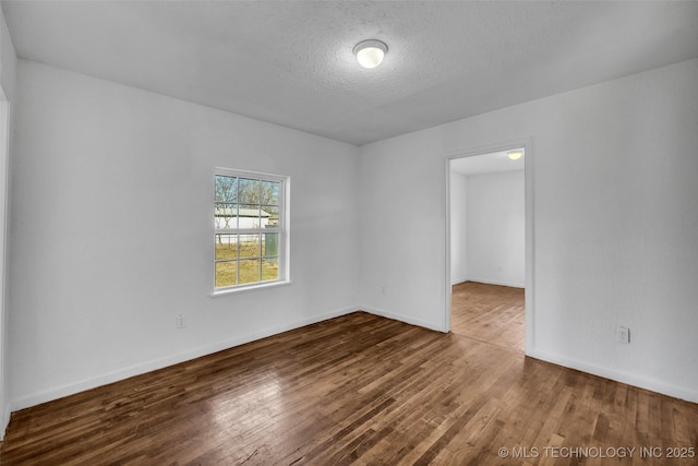 spare room with hardwood / wood-style floors and a textured ceiling