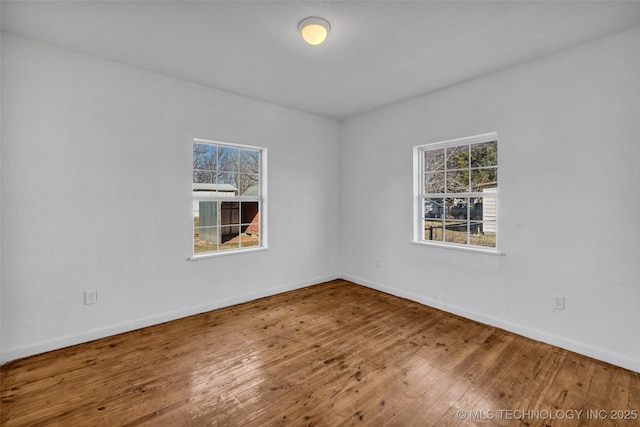 empty room featuring wood-type flooring and a wealth of natural light