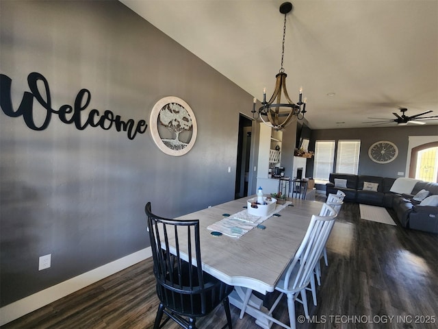 dining space with dark wood-type flooring and ceiling fan with notable chandelier