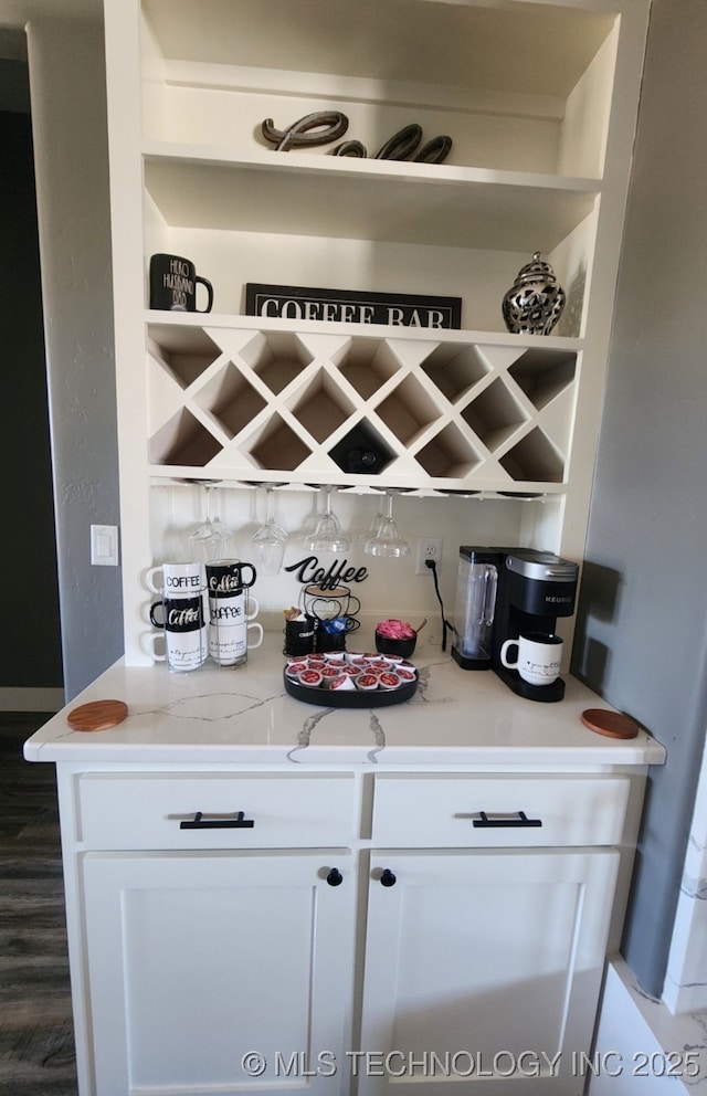 bar featuring white cabinetry and light stone counters