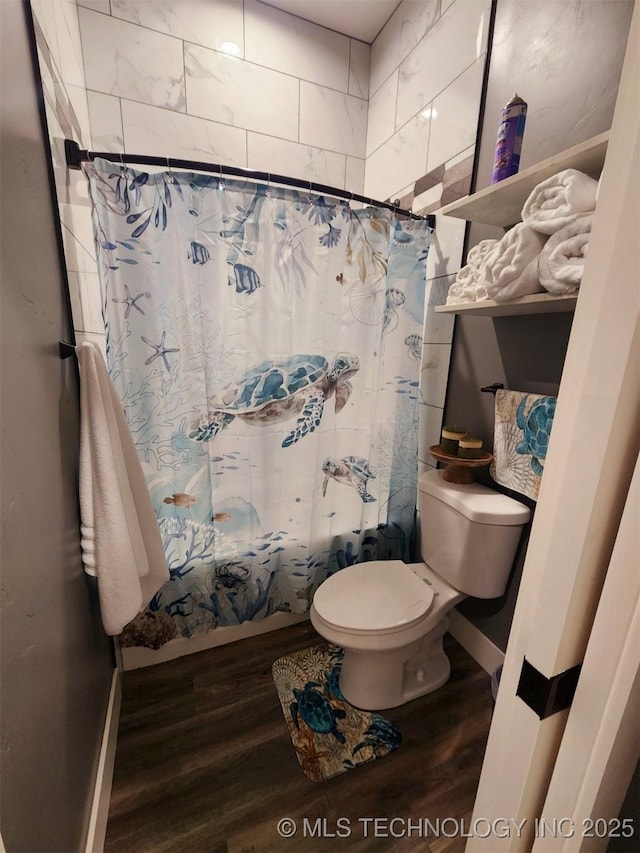 bathroom with hardwood / wood-style flooring, shower / bath combination with curtain, and toilet